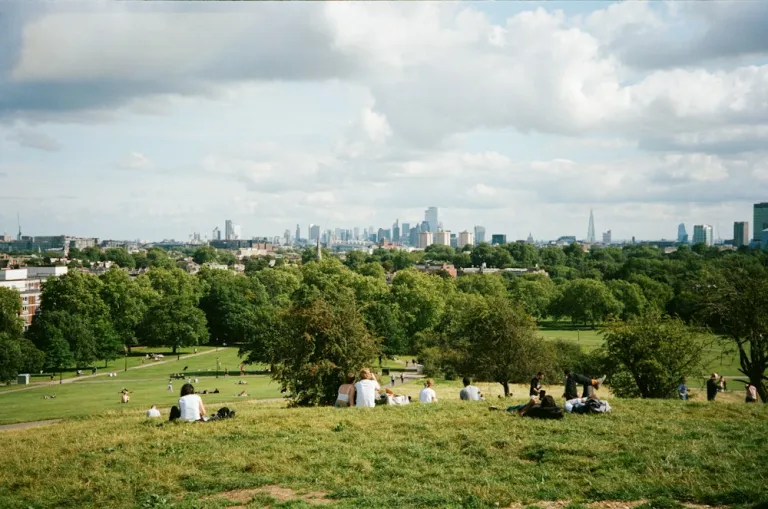 People on Primrose Hill looking towards the London skyline