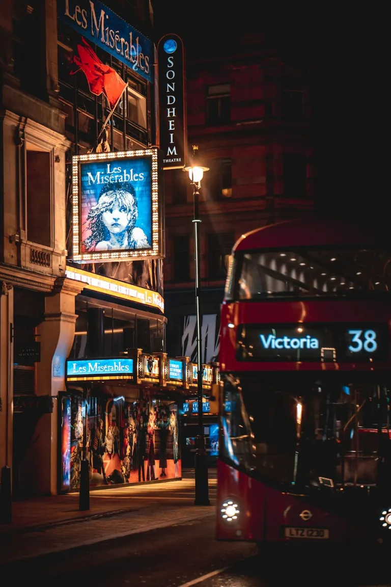 Red double-decker bus on a London street at night
