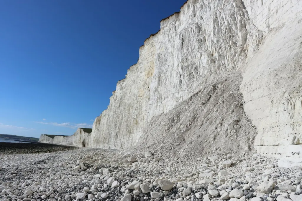 Rocky beach below white chalk cliffs at Birling Gap on the Seven Sisters coast, East Sussex